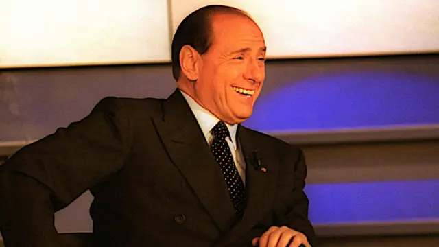 Kandidat Perdana Menteri Italia, Silvio Berlusconi, menghadiri 'Maurizio Costanzo Show'—sebuah program bincang-bincang populer di saluran TV Berlusconi, Canale 5 (bagian dari grup Mediaset)—pada 11 Mei 2001. Ini adalah penampilan publik terakhirnya dalam kampanye pemilihan umum 2001.