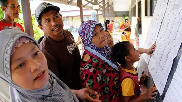 Warga melihat daftar calon legislatif Indonesia pada pemilu 9 April 2014 di desa Temajuk, Kalimantan Barat.