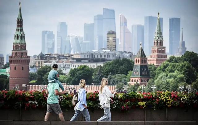 Москва кўчалари бўйлаб ўтиб бораётган одамлар.