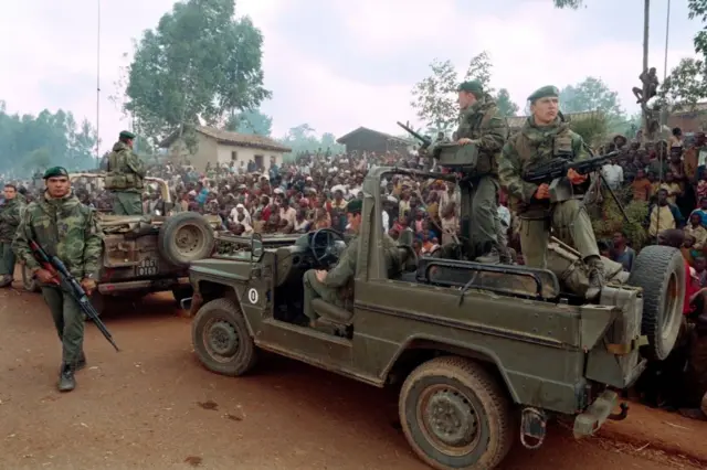 Des Hutus rwandais accueillent un détachement de commandos marines français, dans le cadre de l'opération militaire « Turquoise » menée par la France et lancée le 22 juin avec l'accord du Conseil de sécurité de l'ONU, alors que ceux-ci traversent en voiture un camp de réfugiés situé à environ 4 km de Butare, le 3 juillet 1994.