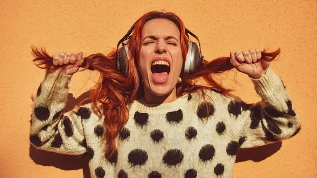 زنی موسیقی گوش میدهد و فریاد میزند