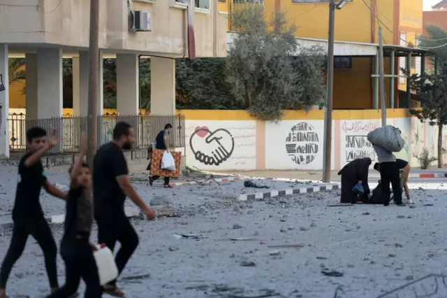 अपना बचा हुआ सामान लेकर अल ज़हरा से निकलते लोग