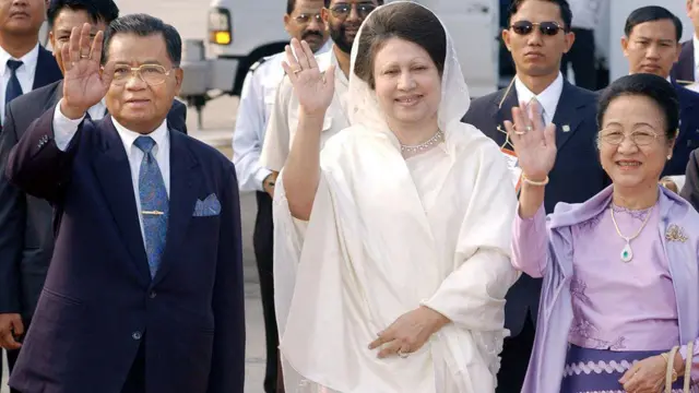 ২০০২ সালের ১৮ই ডিসেম্বর ঢাকার তৎকালীন জিয়া আন্তর্জাতিক বিমানবন্দরে বিদায় অনুষ্ঠানে মিয়ানমারের জান্তা নেতা সিনিয়র জেনারেল থান শোয়ে (বামে) এবং তার স্ত্রী দাউ কিয়াইং কিয়াইং-র (ডানে) সাথে বাংলাদেশের প্রধানমন্ত্রী খালেদা জিয়া গণমাধ্যমের উদ্দেশ্যে হাত নাড়ছেন। 