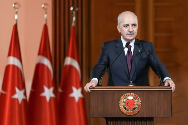 TBMM Başkanı Numan Kurtulmuş açıklama yapıyor. Arkasında Türk bayrakları var. 