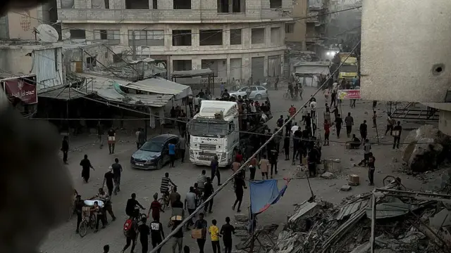 Una vista de palestinos desplazados viajando por una ruta conocida como el "camino de la muerte" para recibir paquetes de alimentos de los puntos de ayuda a pesar del intenso bombardeo israelí y la amenaza de francotiradores en Jan Yunis, Gaza.
