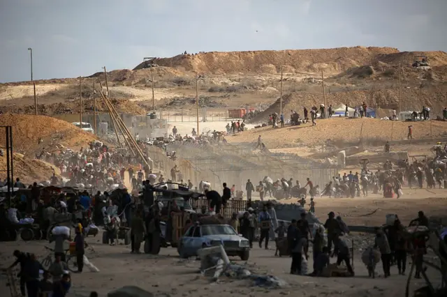 فلسطينيون يحملون أكياس طعام، أثناء عودتهم من نقطة توزيع طعام تديرها مؤسسة غزة الإنسانية المدعومة من الولايات المتحدة وإسرائيل، بالقرب من ممر نتساريم في وسط قطاع غزة في 5 أكتوبر 2025.