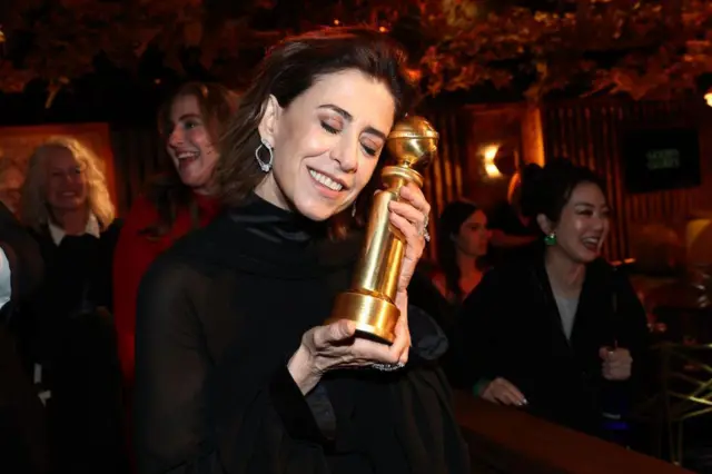 Fernanda Torres segura estatueta da premiação ao lado do rosto