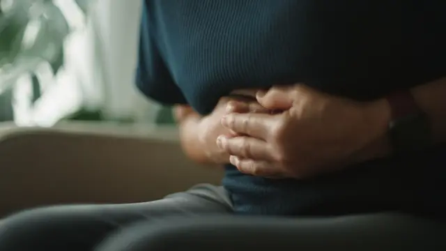 Karnını tutan bir kadın