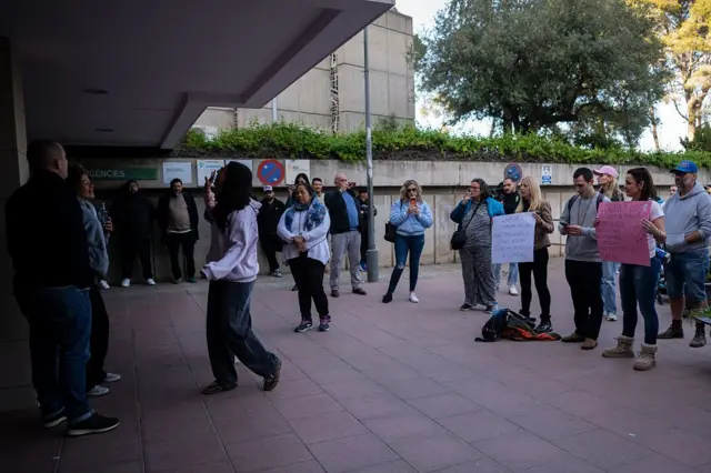 Небольшая группа людей с плакатами у входа в больницу