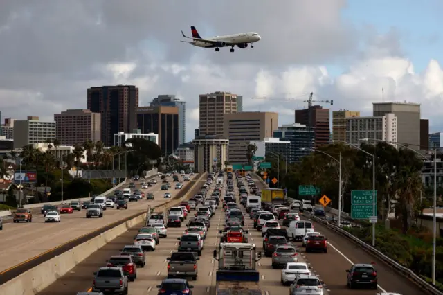 Un avion dans le ciel et des véhicules sur une route