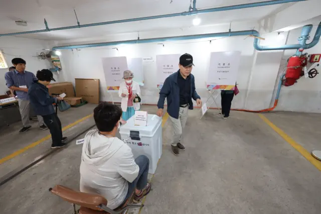 광주 남구 방림동 아파트 지하주차장 투표소에서 시민들이 한 표를 행사하고 있다. 바닥에 주차선들이 보인다