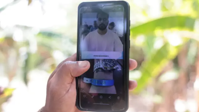 米移民税関捜査局（ICE）の拘束施設にいる若い男性の画像が映っている。手首に番号の印字された青いバンドが巻かれている