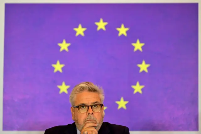 Avrupa Parlamentosu Türkiye Raportörü Nacho Sanchez'in eli çenesinde, düşünceli görünüyor. Arka planda Avrupa Birliği bayrağındaki yıldızlar var. 