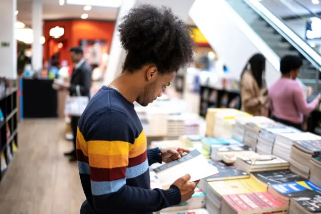 Homem lendo livro em livrarias