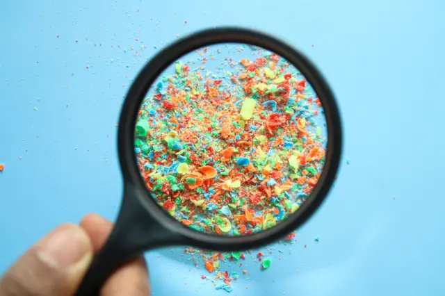 Кольорові шматочки пластику під збільшувальним склом