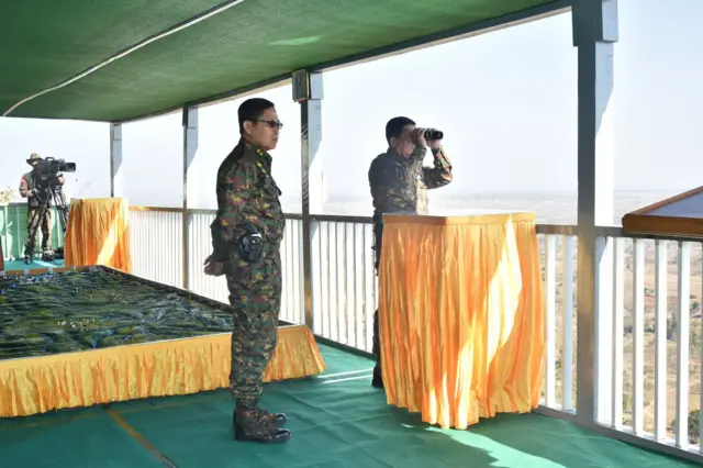 ပြောက်ကျားဝတ်စုံဝတ်ထားတဲ့ ဒုတိယဗိုလ်ချုပ်မှူးကြီးစိုးဝင်းကို ဗိုလ်ချုပ်မှူးကြီးမင်းအောင်လှိုင်နဲ့အတူ တွေ့ရစဥ်
