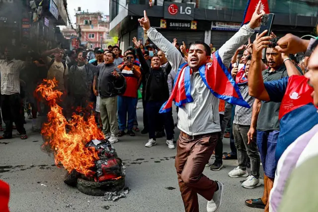 People displaying Nepal's national flag burn tyres during a demonstration to condemn the police's deadly crackdown on protesters in Kathmandu on September 9, 2025, a day after demonstrations over social media prohibitions and corruption by the government. Nepal rolled back its social media ban on September 9, a day after at least 19 people were killed in youth protests demanding that the government lift its restrictions and tackle corruption. All major social media apps were working, an AFP reporter in Kathmandu said, as the government ordered a probe into the violence that saw police launch one of the deadliest crackdowns on protesters for years. AFP via Getty Images)
