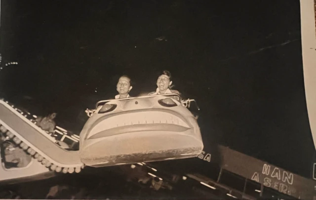 Fuar alanındaki lunaparkta uçan arabaya binen iki kişi