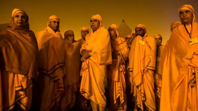 ਹਰਿਦੁਆਰ ਵਿੱਚ ਗੰਗਾ ਦੇ ਕੰਢੇ ਖੜ੍ਹੇ ਭਗਵਾ ਕੱਪੜੇ ਪਹਿਨੇ ਲੋਕ