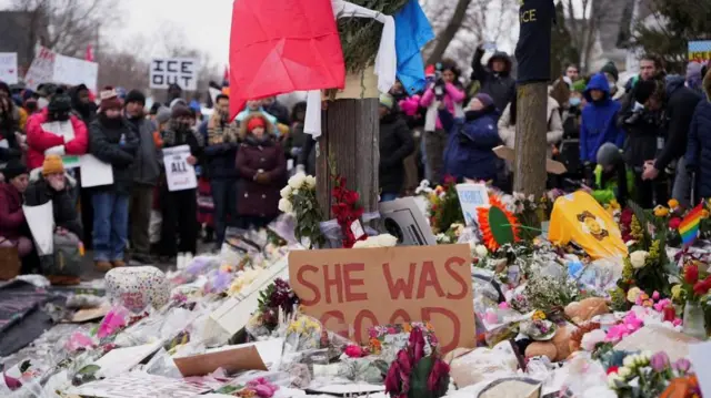 殺害現場を、防寒着姿の大勢が取り囲んで見つめている。「ICEは出ていけ」と書かれたプラカードを掲げる人もいる