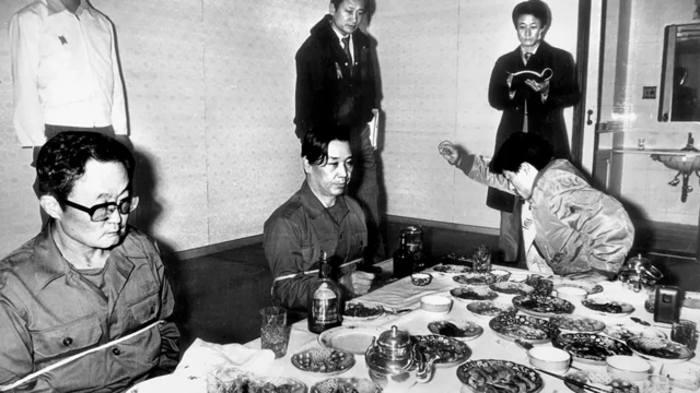 کیم در حالی که اسلحه‌ای در دست دارد صحنه تیراندازی را بازسازی می‌کند. در حالی که ماموران تحقیق تماشا می‌کنند 