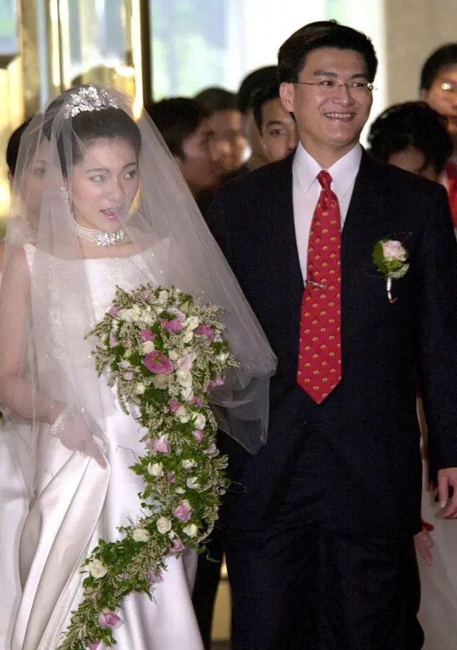 2001年9月27日,台湾总统陈水扁女儿陈幸妤(左)与骨科医生赵建铭(右)面带微笑地走进台北市中心一家酒店,他们将于当天晚些时候在此举行婚礼。