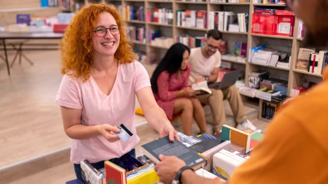 Jovem entregando livro e segurando cartãocadastro loterias onlinecrédito dentrocadastro loterias onlinelivraria