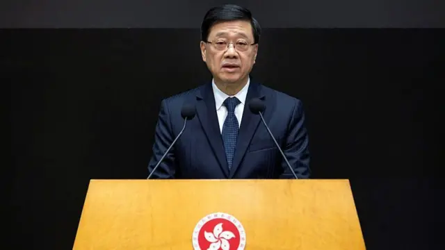 ダークスーツ姿の李氏が演台で口を開いている