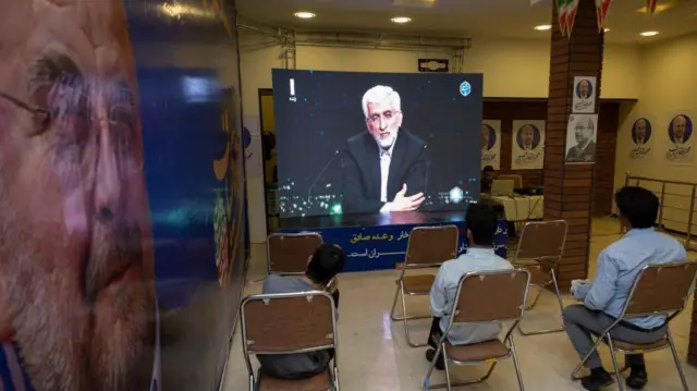 جلیلی در تلویزیون و پوستر قالیباف بر دیوار