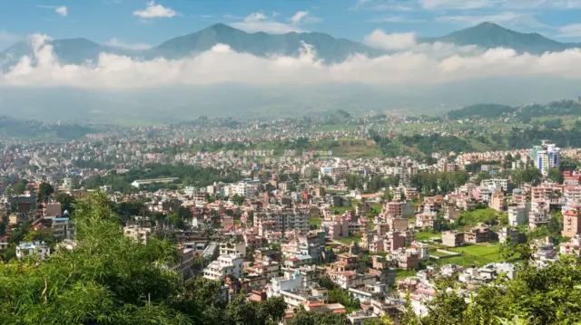 منظر للعاصمة النيبالية كاتماندو، مع السحب والجبال في الخلفية