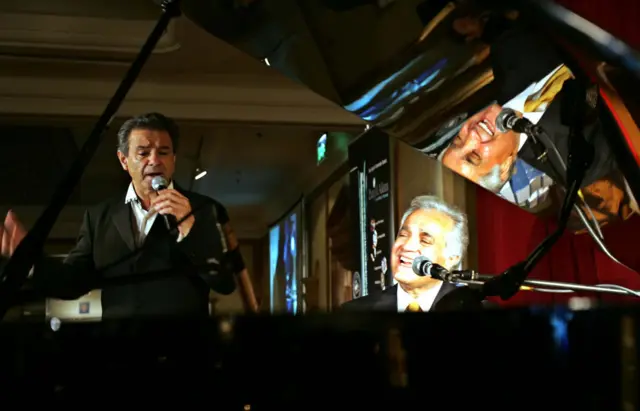 خواننده ایرانی عارف (چپ) و انوشیروان روحانی، پیانیست سرشناس ایرانیِ ساکن لس‌آنجلس، در کنسرت و شام خیریه‌ای در دوبی (۱۵ فوریه ۲۰۰۷)