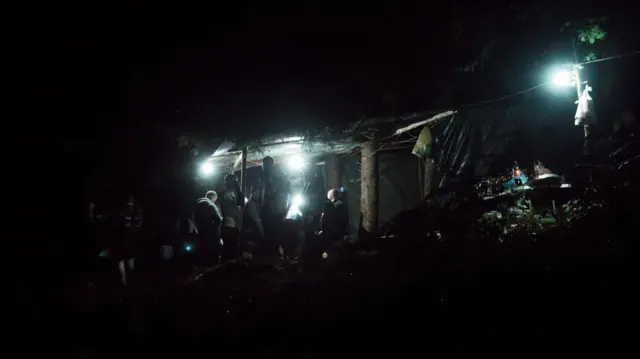 Siluete ljudi u mraku ispod nadstrešnice