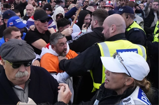 Manifestantes protestan para detener la salida de un furgón policial después de que un activista fuera detenido por la policía tras colgar una bandera de la Unión en las oficinas de la autoridad local en Epping, sureste de Inglaterra.