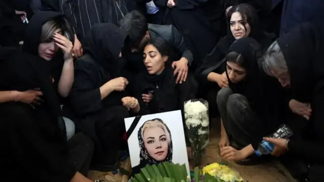 Женщины в черных одеждах у портрета погибшей 