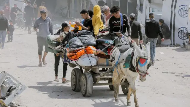 یک خانواده با گاری وسایل خود را می‌برند