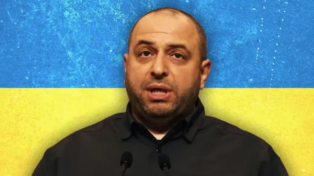 رستم عمروف در مقابل پرچم اوکراین به تصویر کشیده شده است.