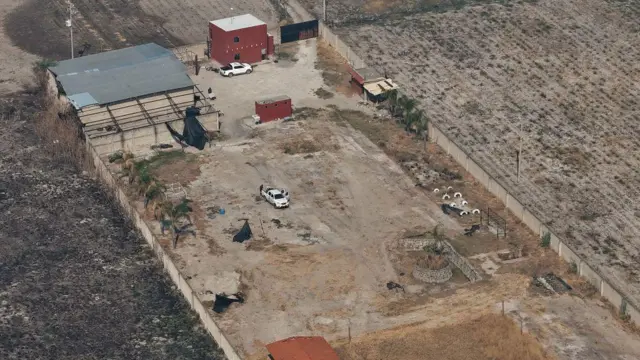 Aworan ibẹ ni kikun. O ṣafihan awọn ibi ti wọn n da idọti si pẹlu awon ile kan to ta kete ti wọn fi ogiri yipo