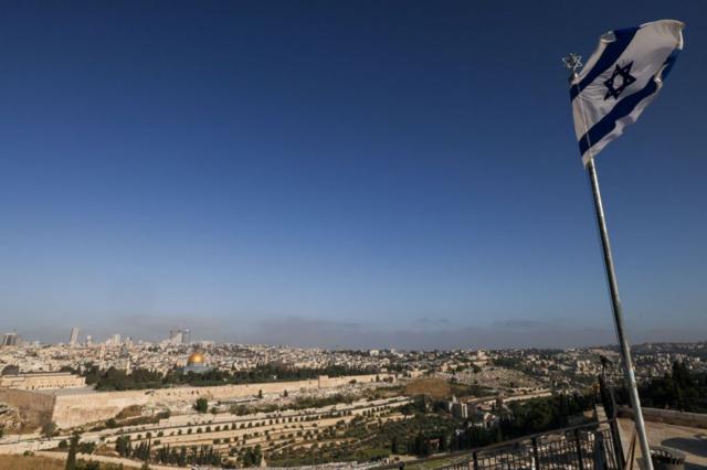 Una bandera israelí ondea en el Monte de los Olivos, con vistas al recinto de la mezquita de Al Aqsa y al horizonte de la ciudad de Jerusalén.