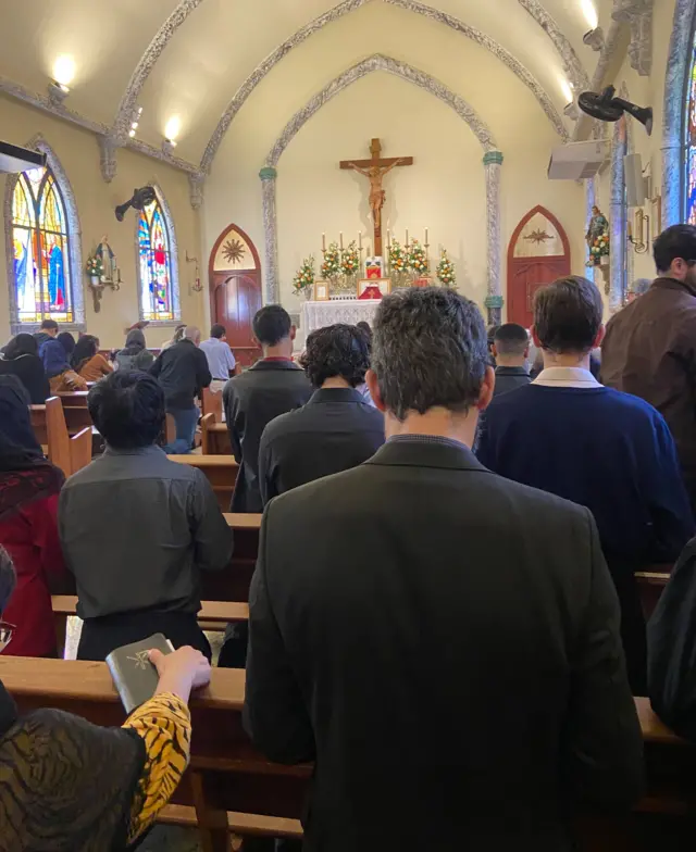 Imagem feita dos últimos bancos da igreja mostra capela lotada de fiéis