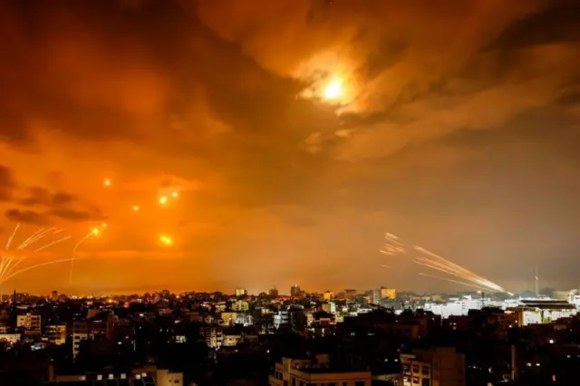 Imagem mostra céu laranja enquanto sistemada quina de hojedefesa israelense intercepta mísseis lançados a partirda quina de hojeGaza