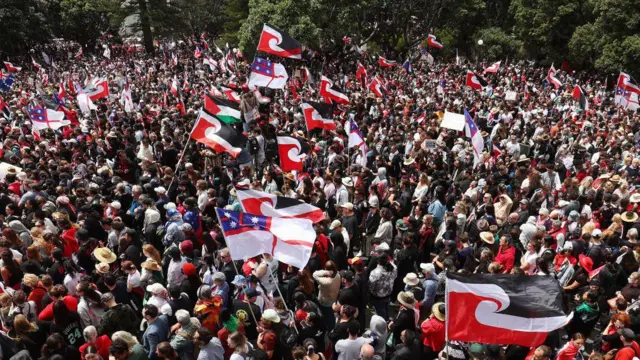 Miembros de la comunidad maorí, toman parte en una marcha de protesta en Wellington, 19 de noviembre, 2024.