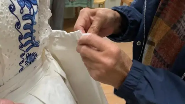 Žena ušiva haljinu drugoj ženi