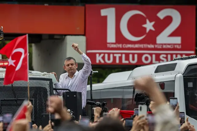 Özgür Özel, Meclis'e yürüyüşte TOMA'nın üzerine çıkmış durumda, elini kaldırmış