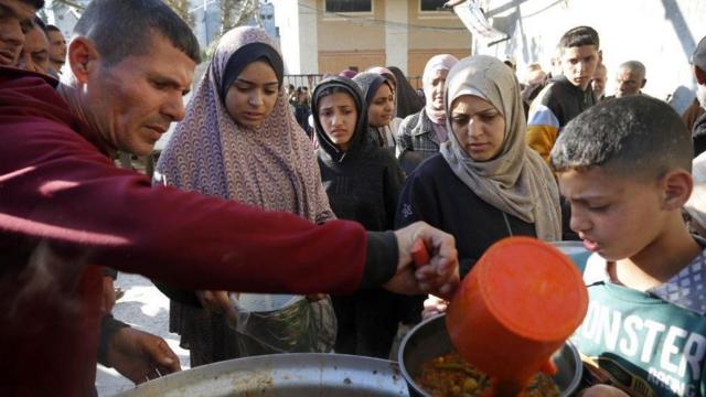 Palestinos fazem fila para receber alimentos de organizações humanitárias