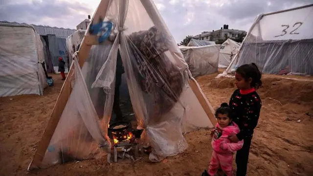 Niños frente a una carpa de plástico