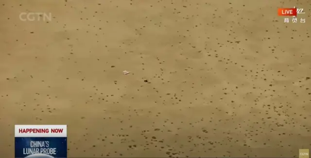 Captura de tela de uma transmissão ao vivo mostrando a sonda enquanto ela pousa na Mongólia Interior