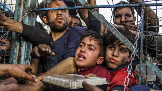 کودکان گرسنه فلسطینی در میان جمعیتی انبوه در انتظار دریافت غذا از سازمانهای امدادی