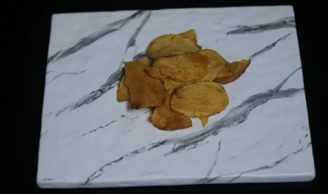 صورة تظهر حفنة من رقائق البطاطا.