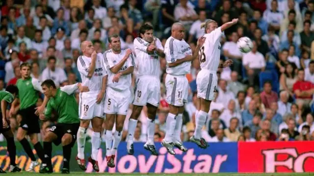 بازیکنان رئال مادرید استبان کامبیاسو، زین‌الدین زیدان، لوئیس فیگو، رونالدو نازاریو و دیوید بکام دیوار دفاعی مقابل یک ضربه ایستگاهی در سال ۲۰۰۳ را تشکیل داده‌اند