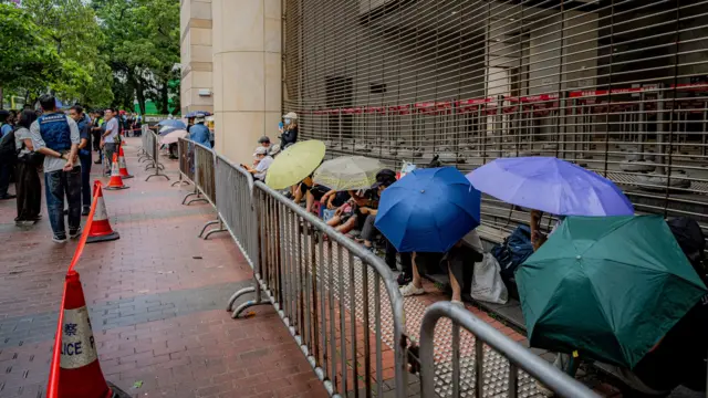 香港西九龙裁判法院外有意排队民众冒雨打伞排队,等候入庭(21/8/2026)